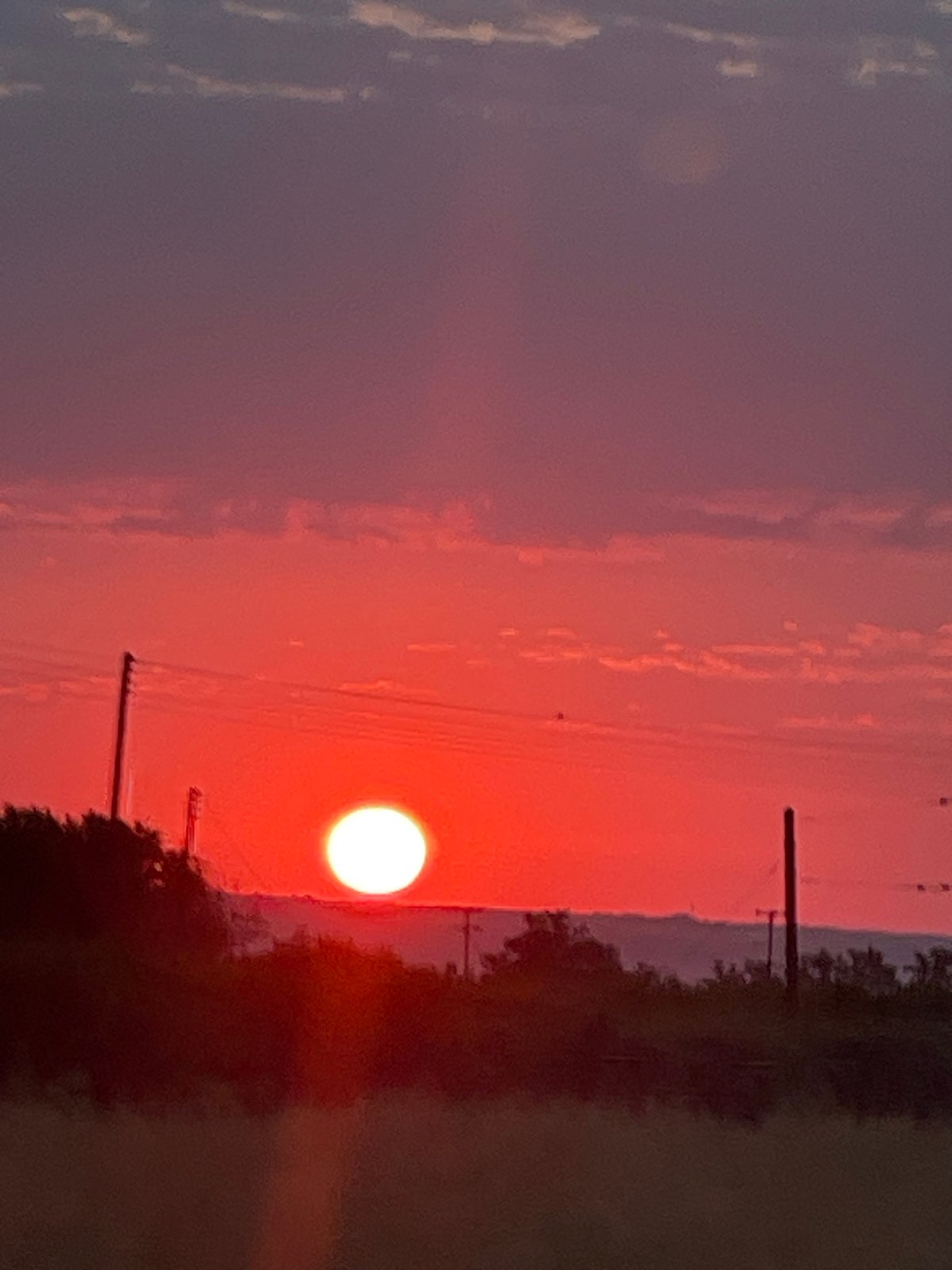Wide sunset sky transitions from blue-green to deep red
