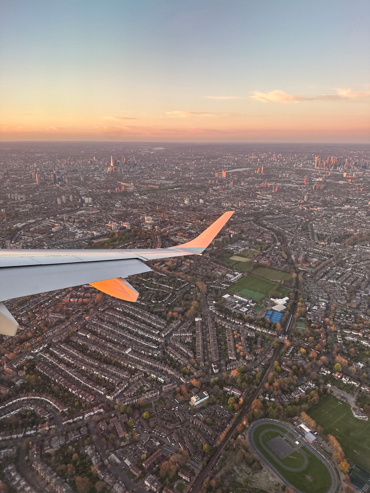 Aircraft passenger captures aerial dawn view over dense London neighborhoods