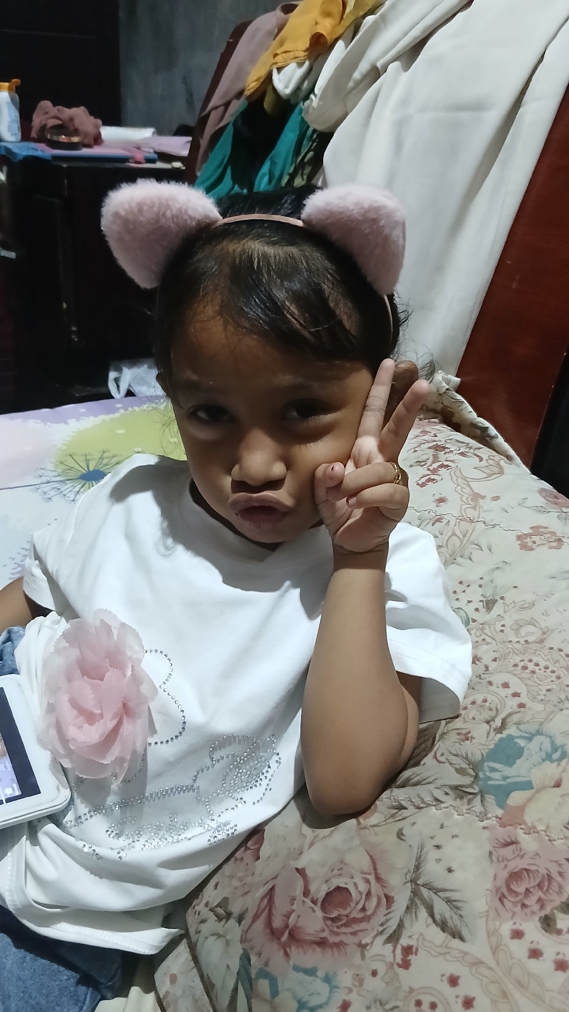 Portrait in white embellished tee with pink flower detail, Indonesia