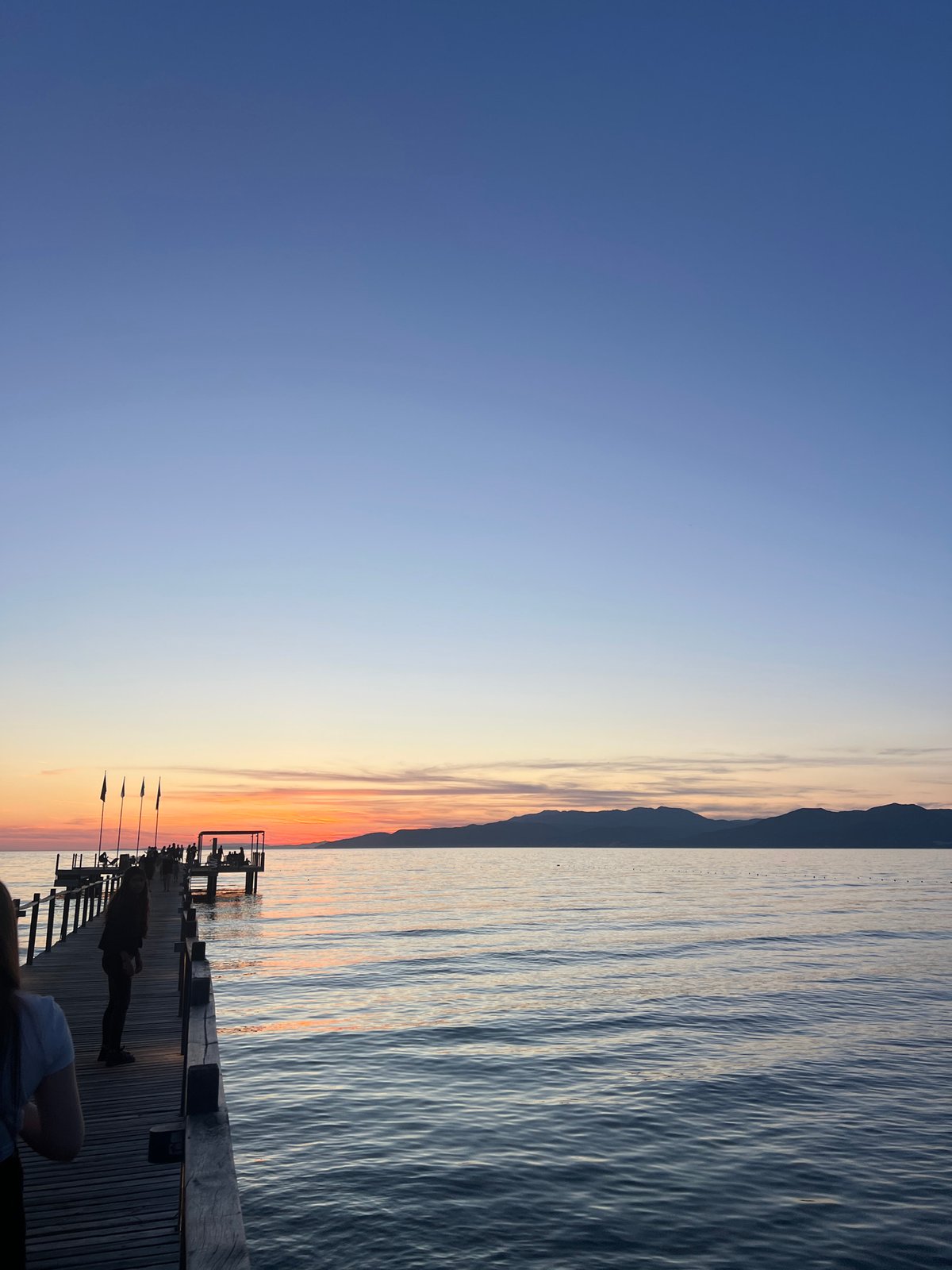 Sunset gathering documented on wooden pier in Selçuk, Turkey