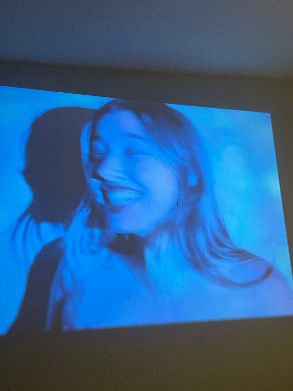 Blue-toned woman's portrait projected on walls in Maidstone home