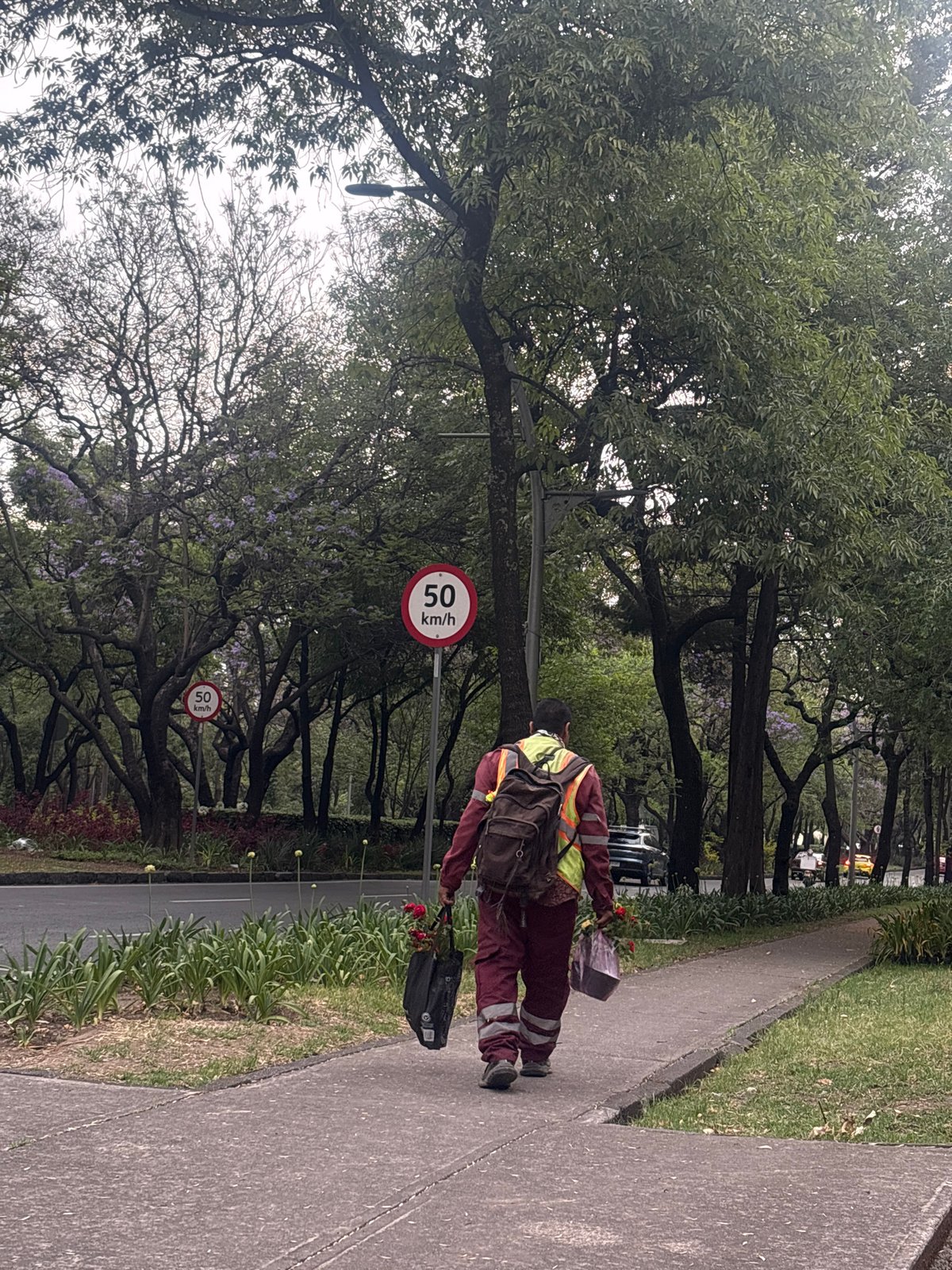 Worker in high-vis vest walks Mexico City sidewalk