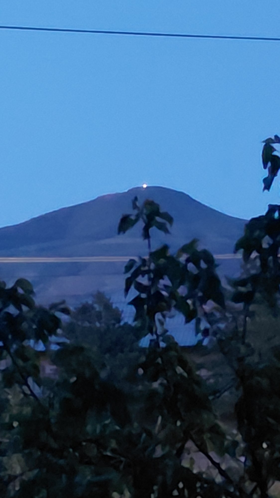 Twilight views of a lit mountain summit over Abovyan, Armenia