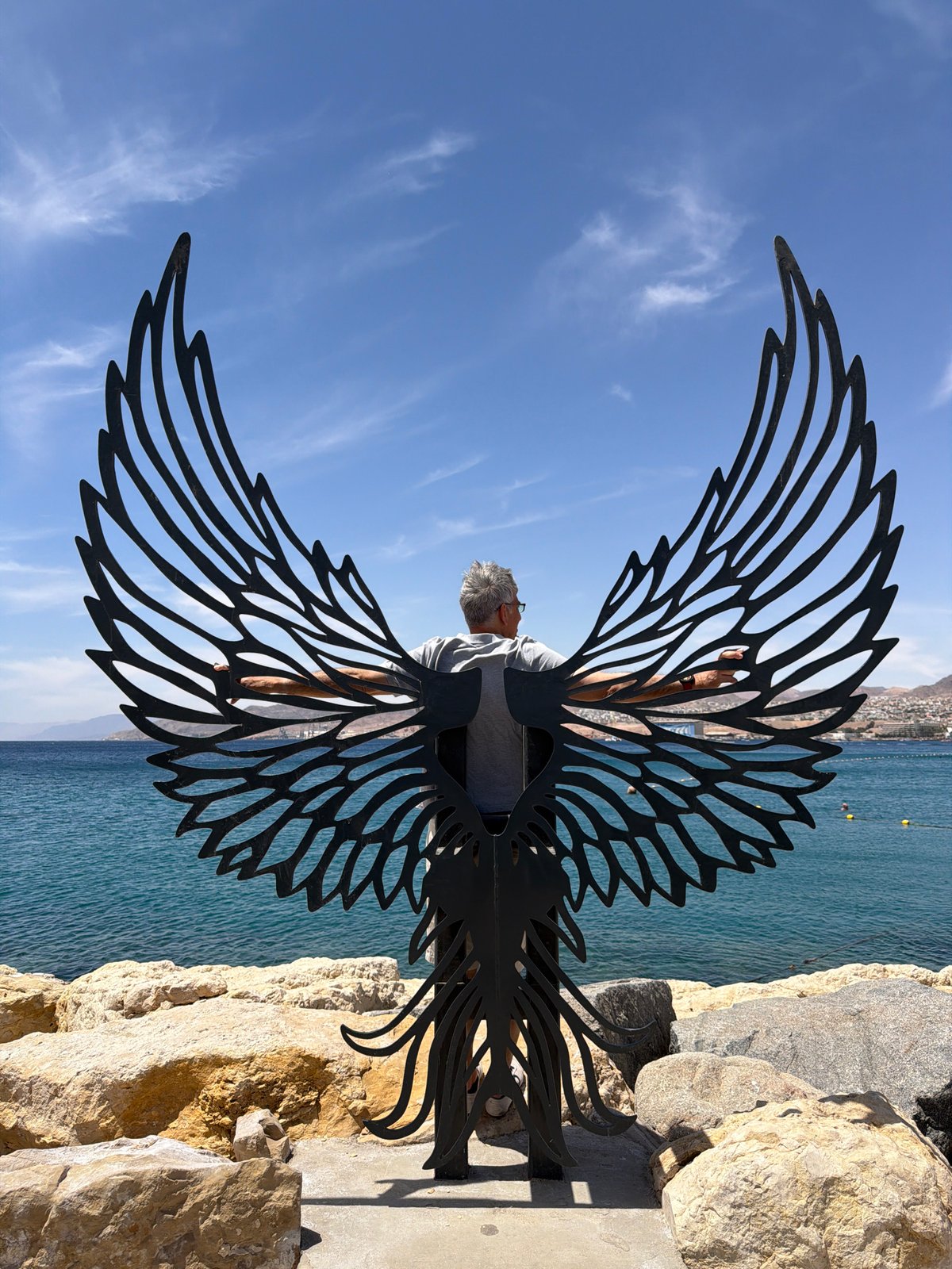 Man views wing sculpture at Eilat coastal area