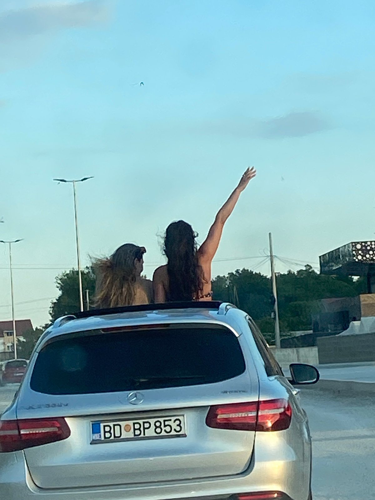 Women celebrate through sunroof on dusty Montenegro road