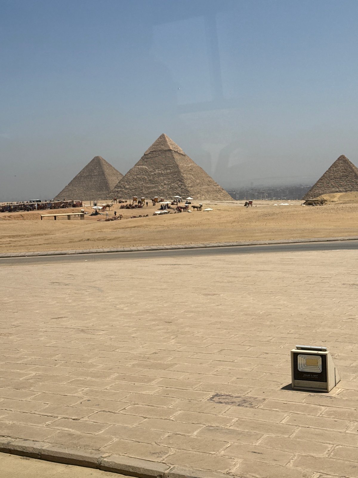 Tourists photograph Giza pyramids on hazy morning