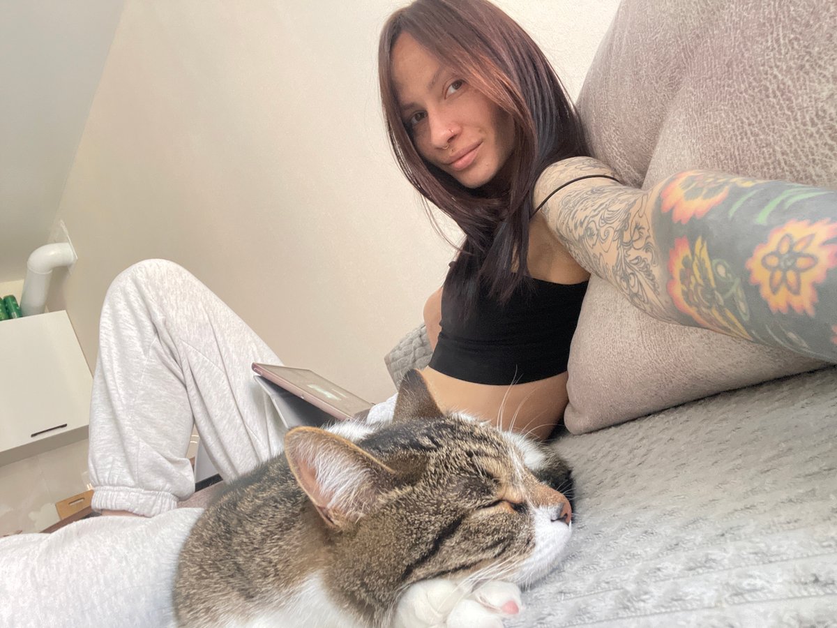 Woman relaxes with sleeping cat on sofa in Izhevsk
