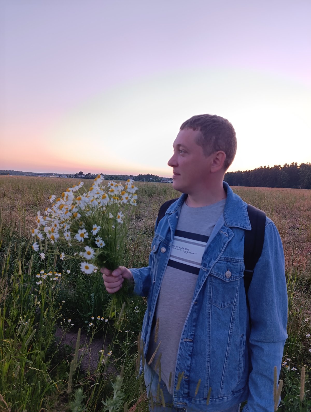 Picking wildflowers in a golden field at dusk