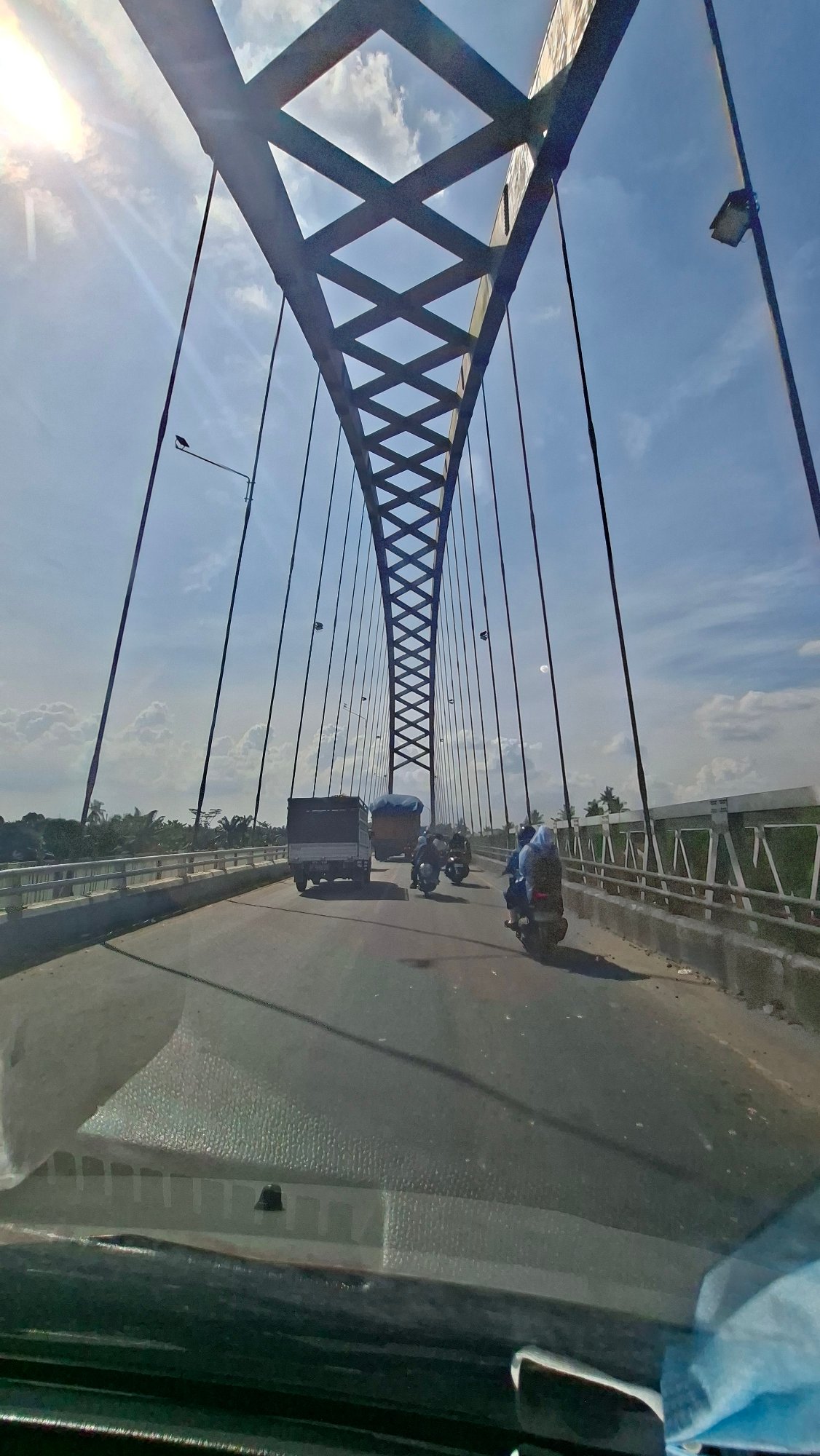 Driving across Stabat's arched cable bridge in light traffic