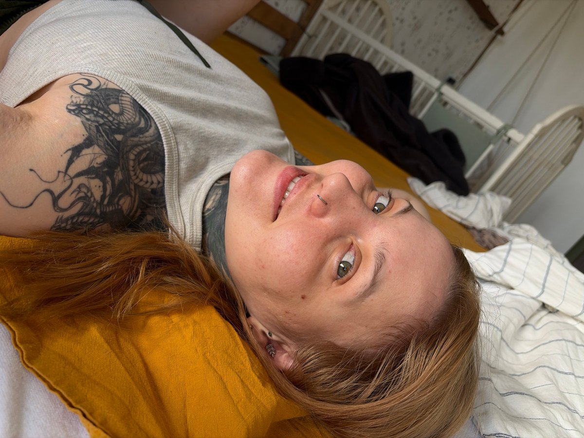 Person with piercings, tattoos observed resting indoors in Chaikovsky