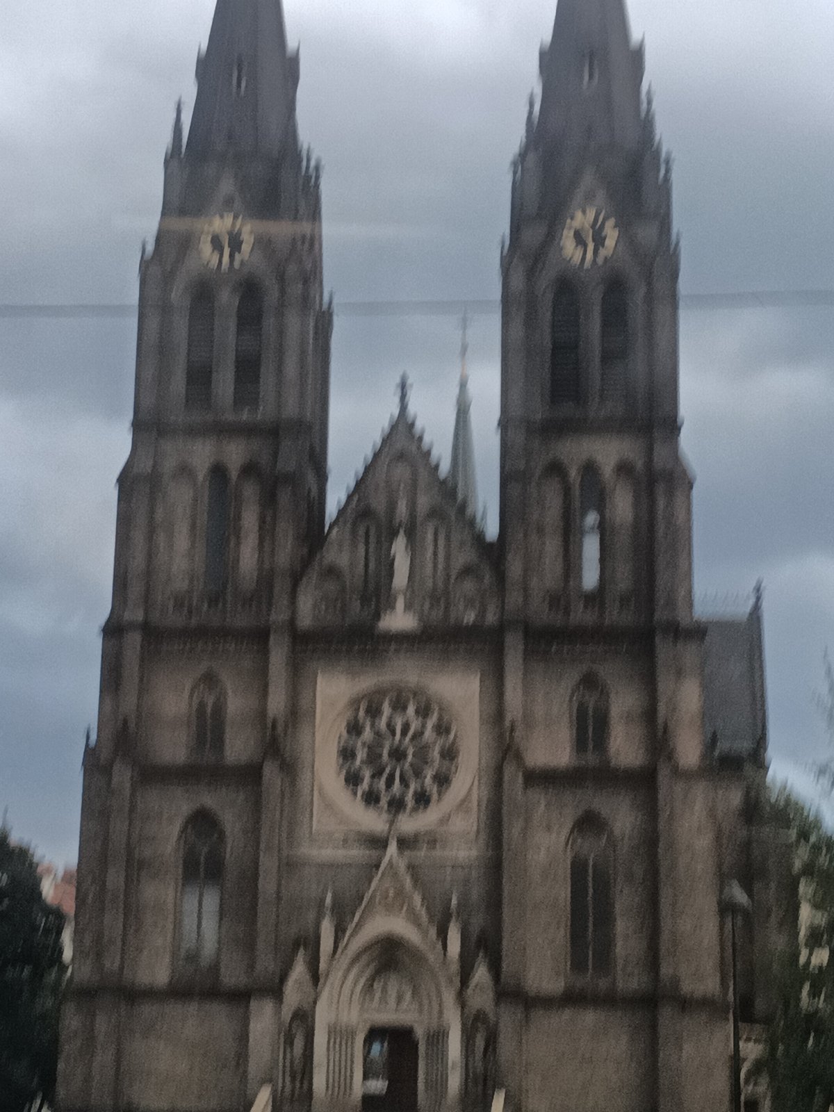 Rainy morning tram ride past Vyšehrad's Gothic basilica, Prague