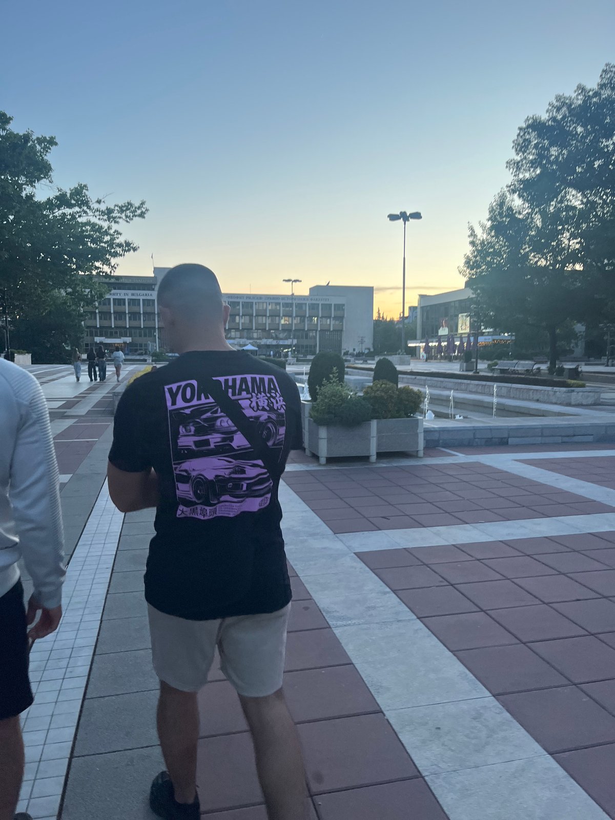 Two men visit fountain area in Blagoevgrad during afternoon walk
