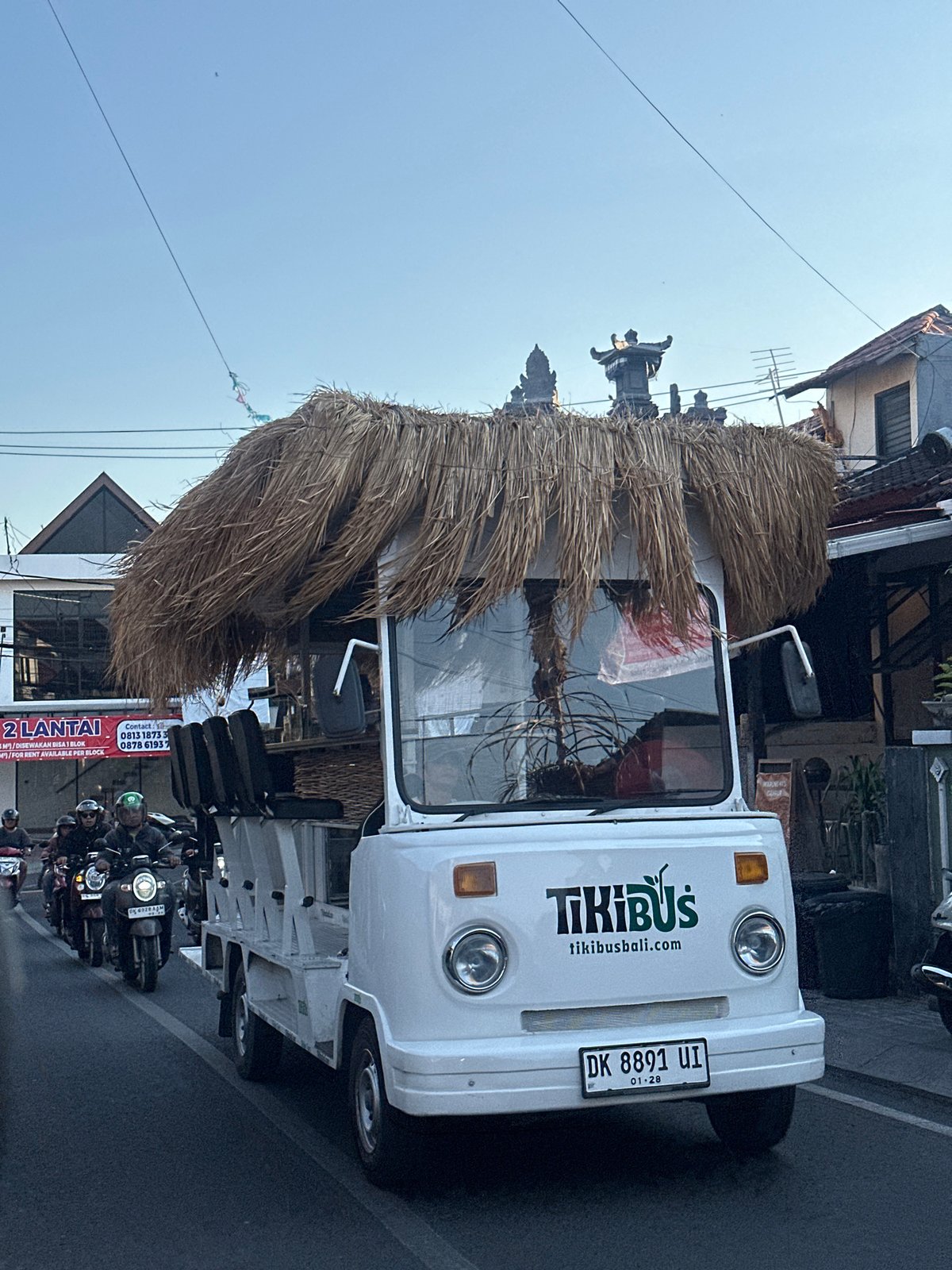 Tiki bus and street food cart in busy North Kuta morning