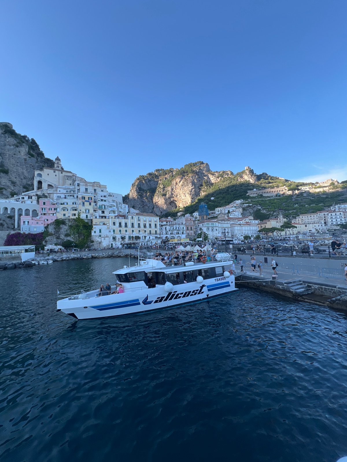 Ferry docks with passengers in Pogerola, Italy