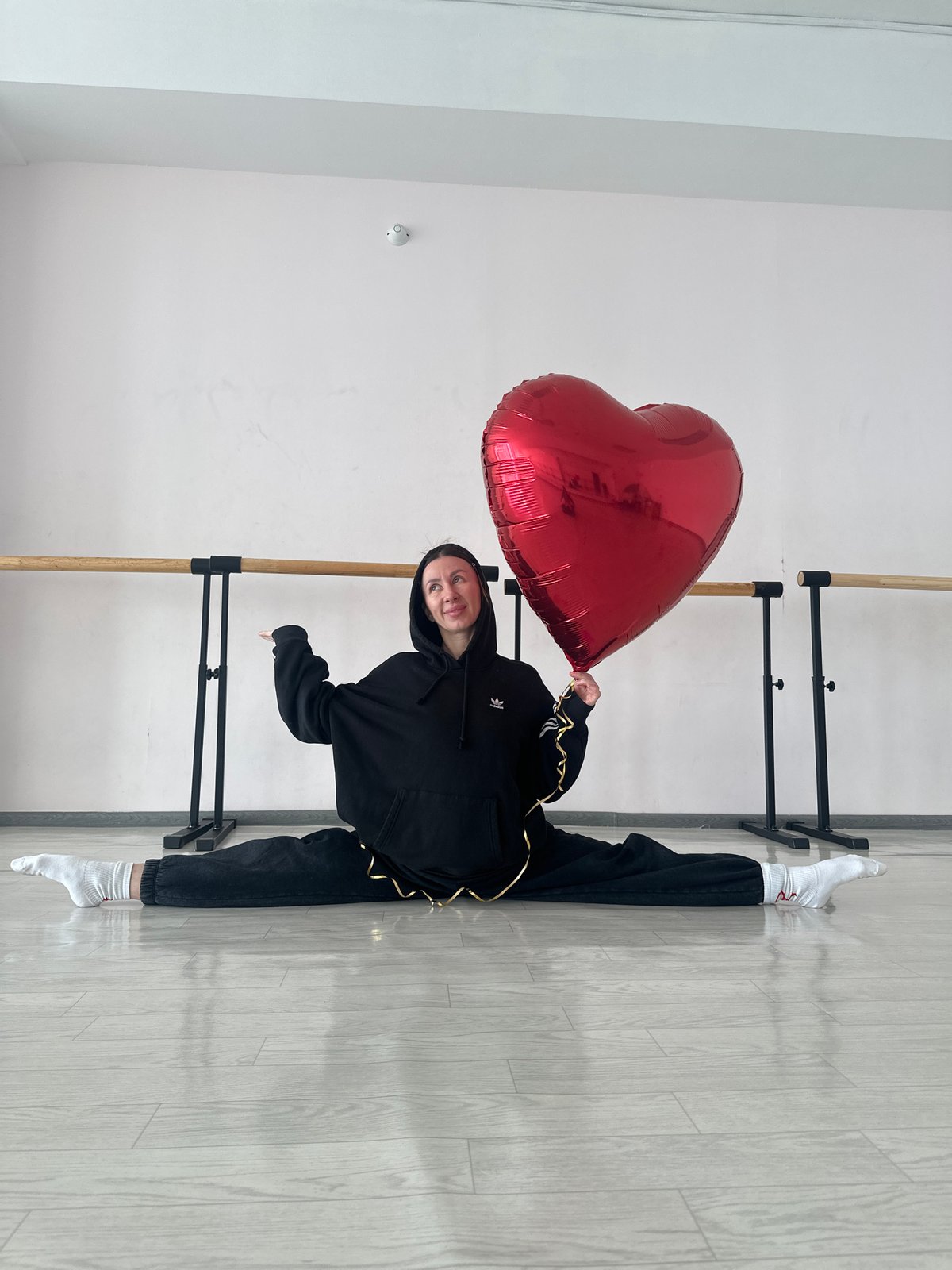 Woman performs acrobatic dance routine with heart balloon in Russian studio
