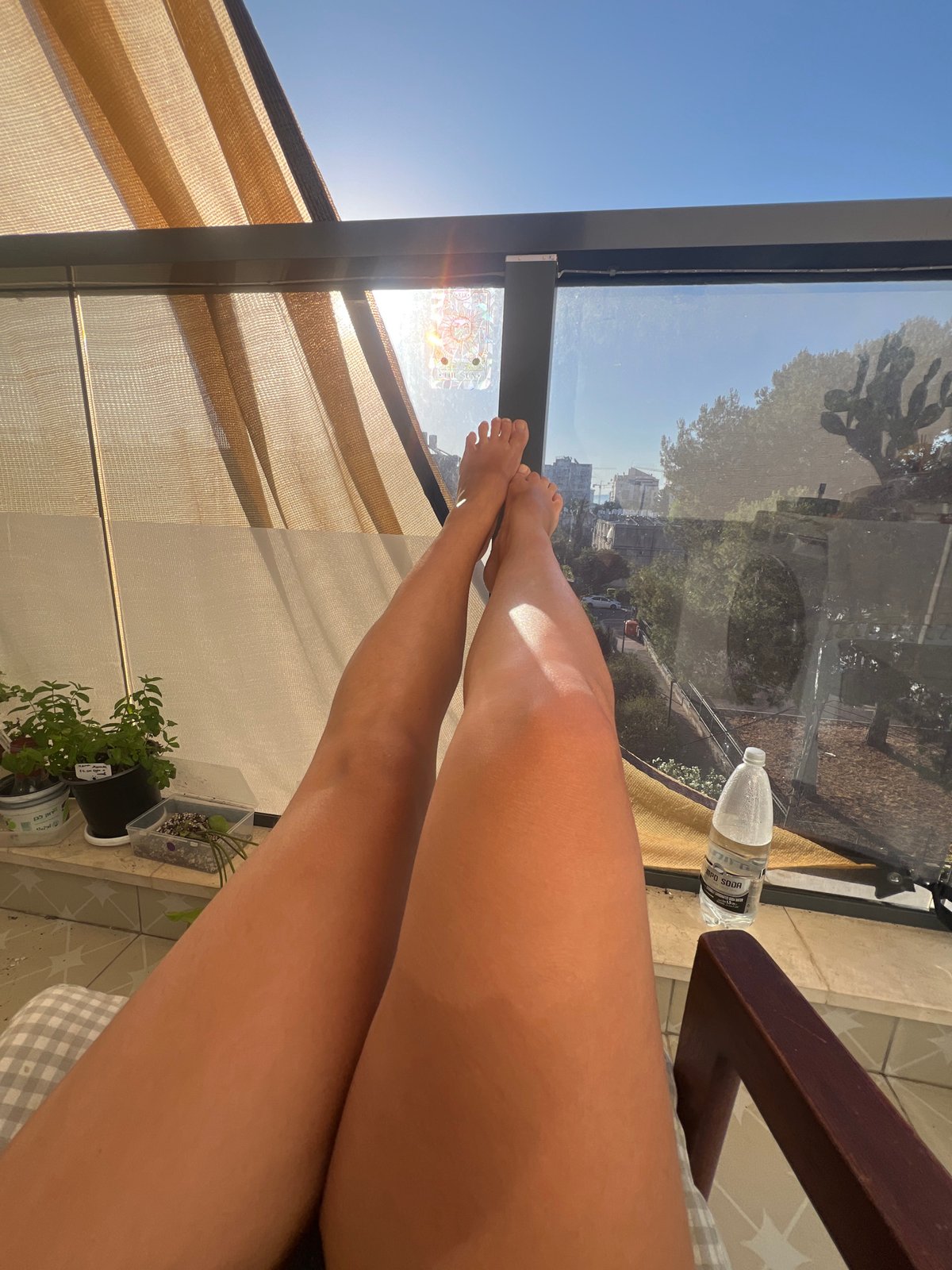 Person relaxes on sunny balcony in Kiryat Bialik