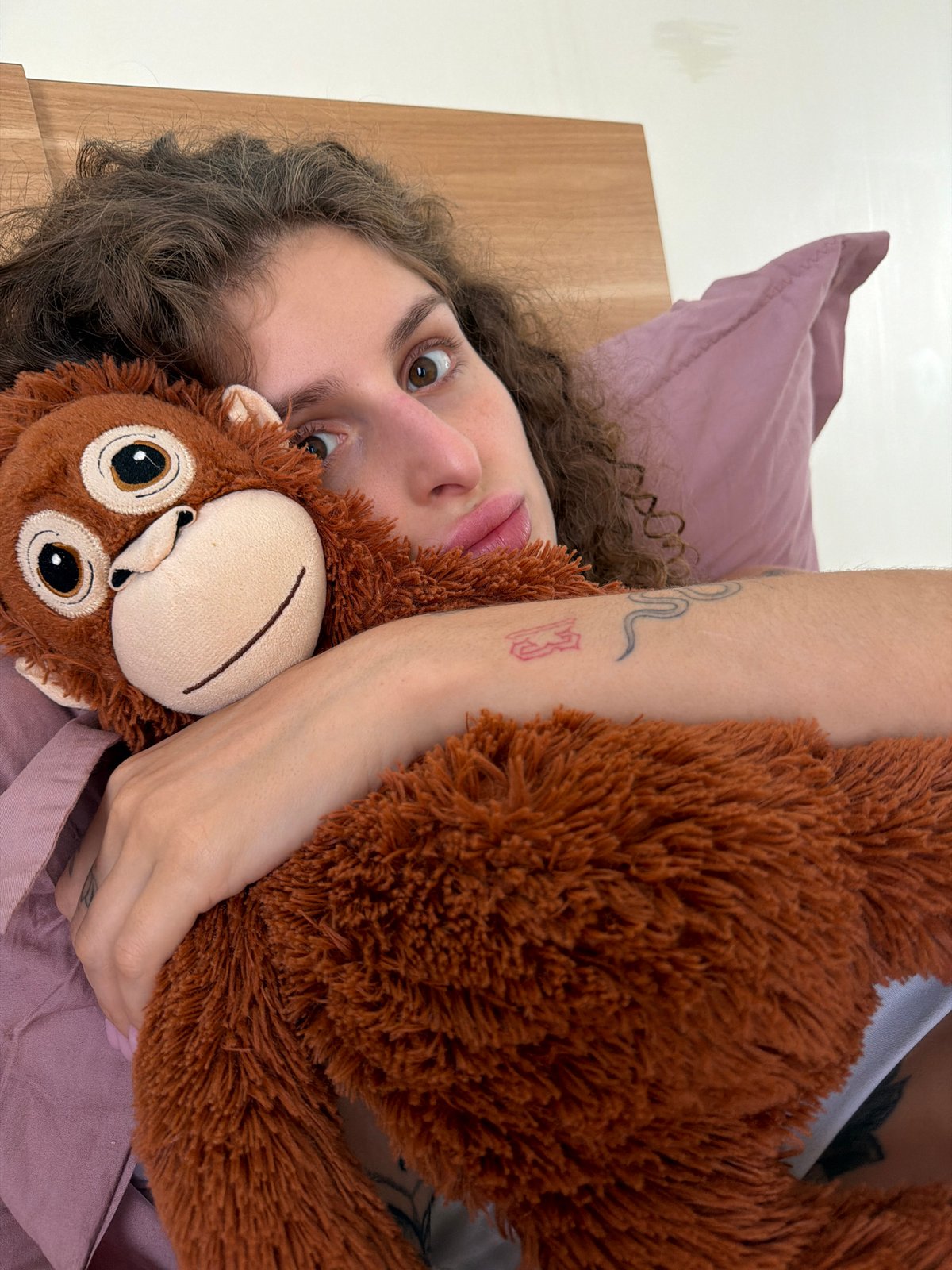 Woman cuddles stuffed monkey in bedroom photos, North Kuta
