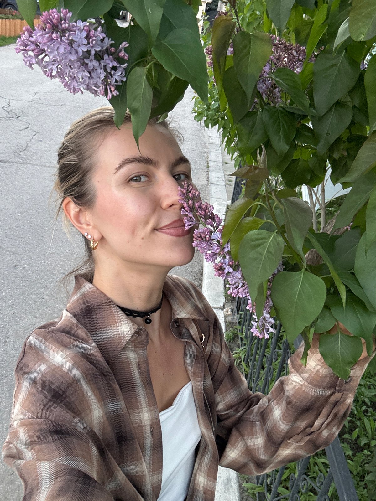 Woman photographs herself near distinctive brick building in urban area
