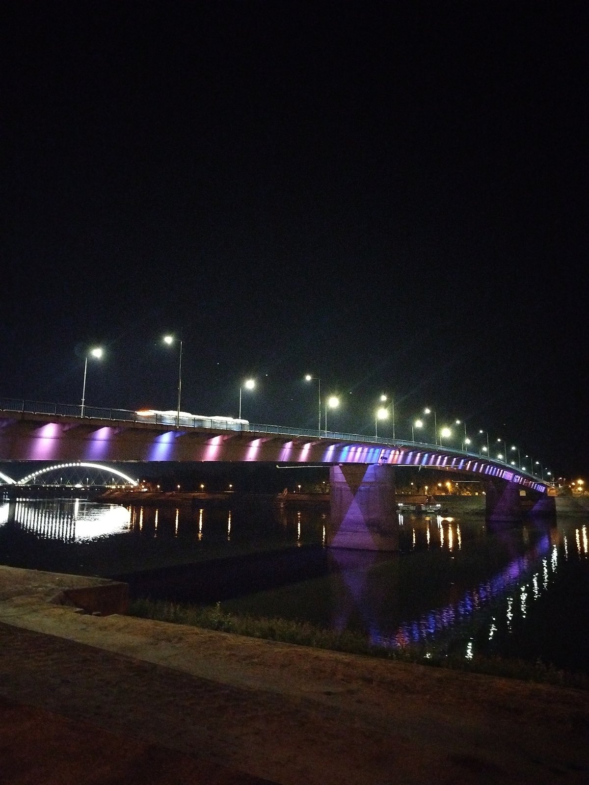 Novi Sad's illuminated riverfront and bridges after dark