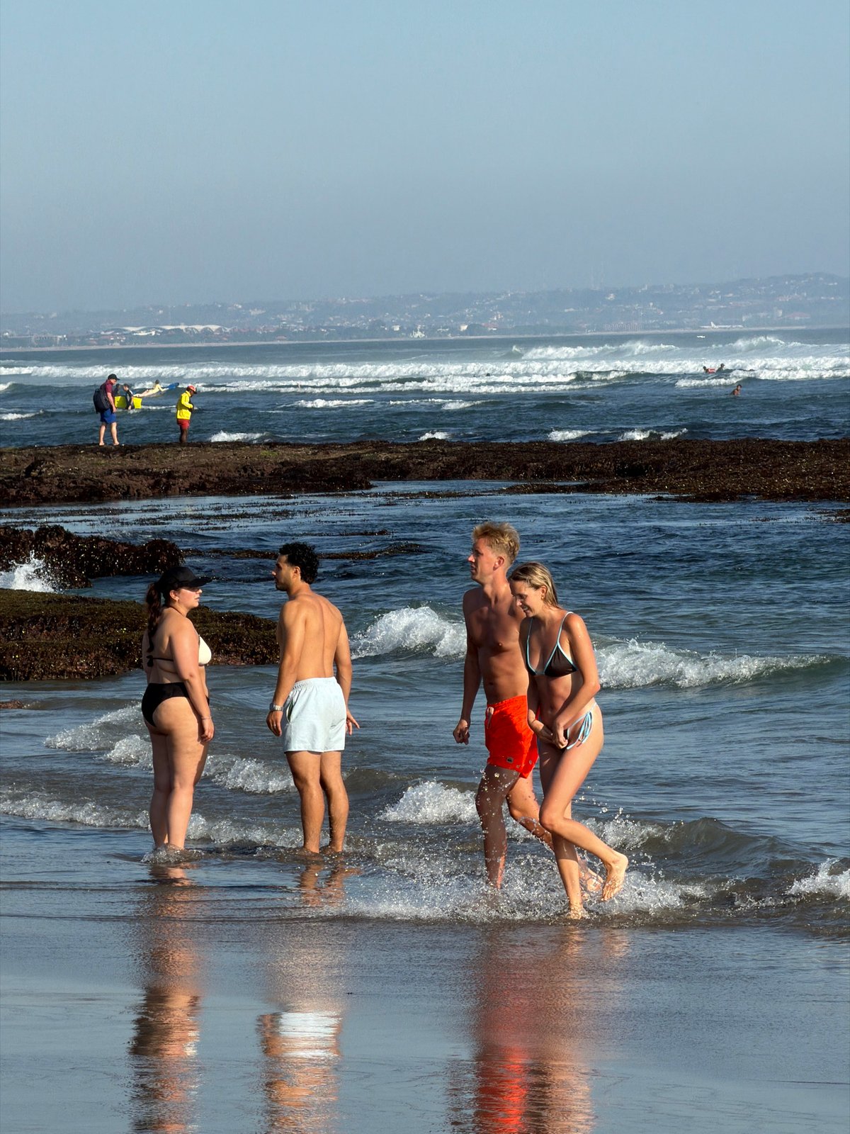 Busy beach morning in North Kuta — surf, sand, and tide pools