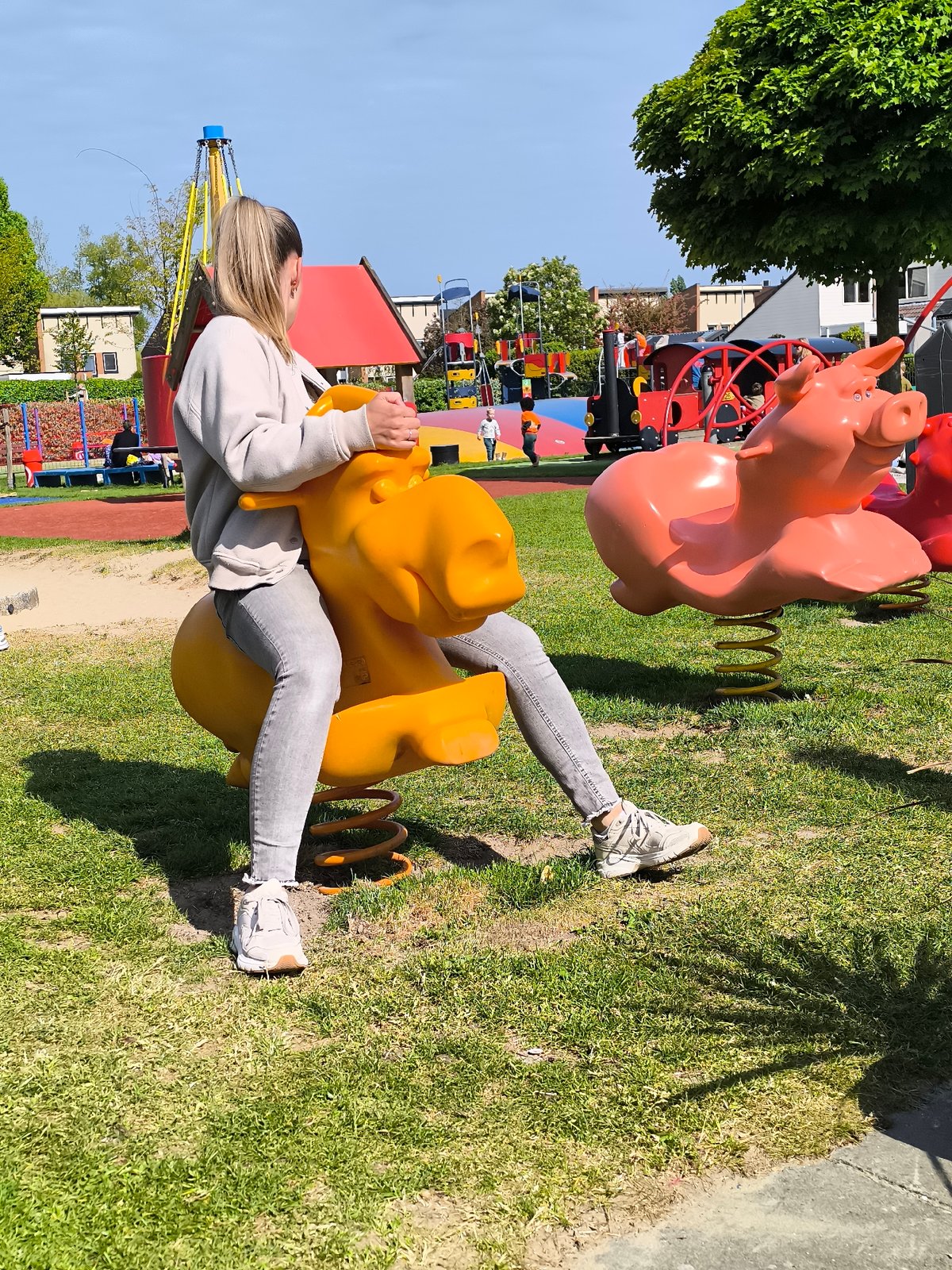Woman rides playground spring rider in Alkmaar