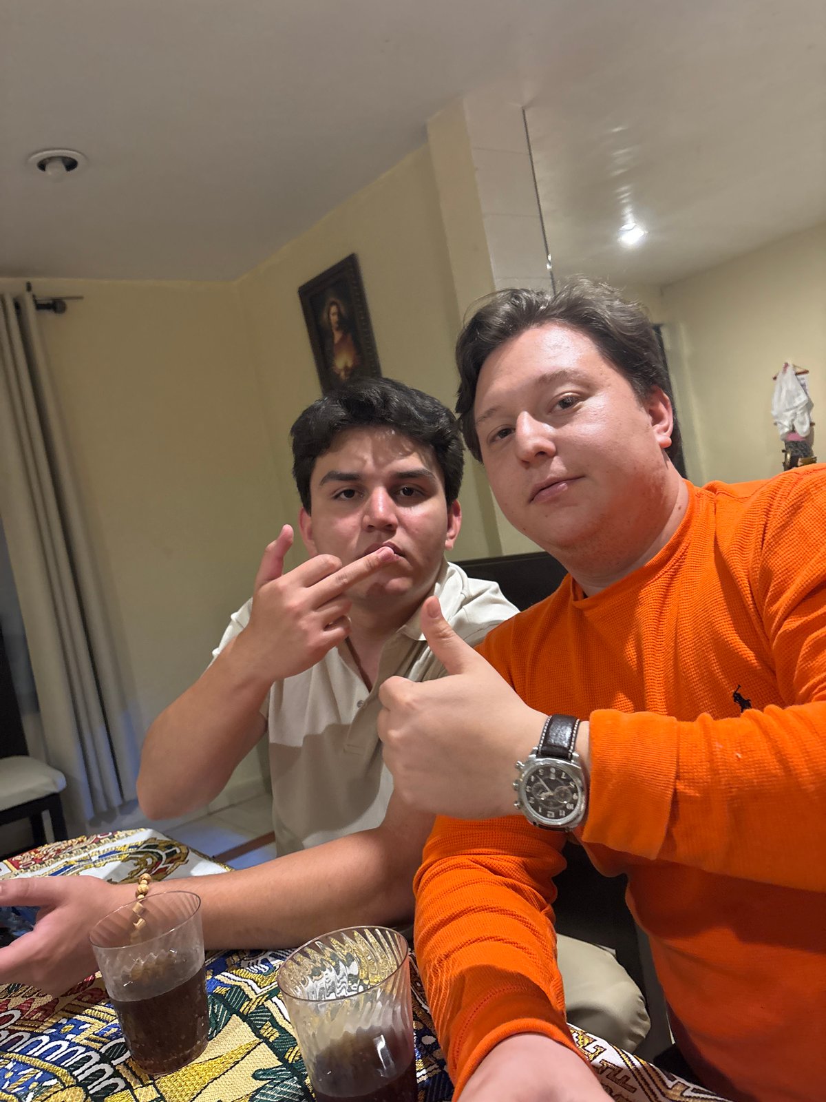 Two men take selfie with drinks in Puebla home