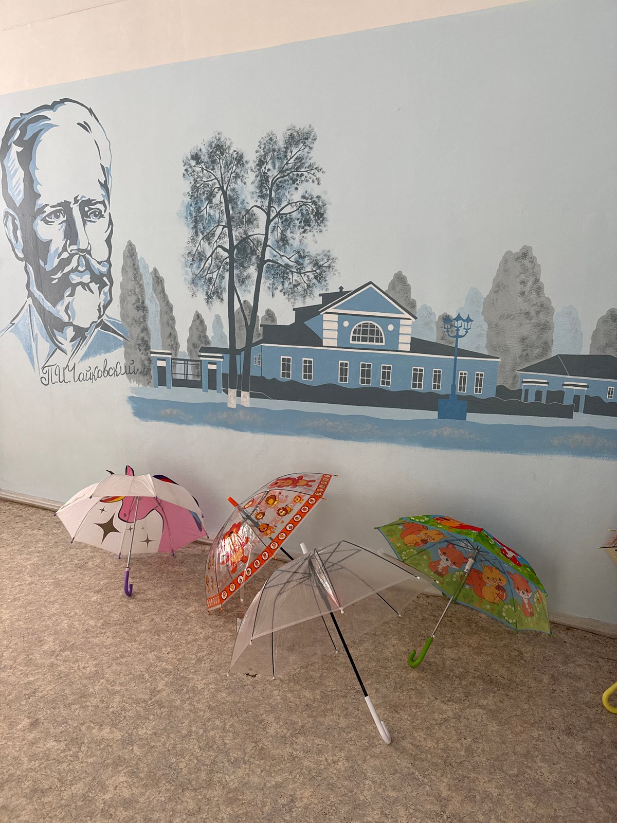 Children with umbrellas and street murals observed in Votkinsk