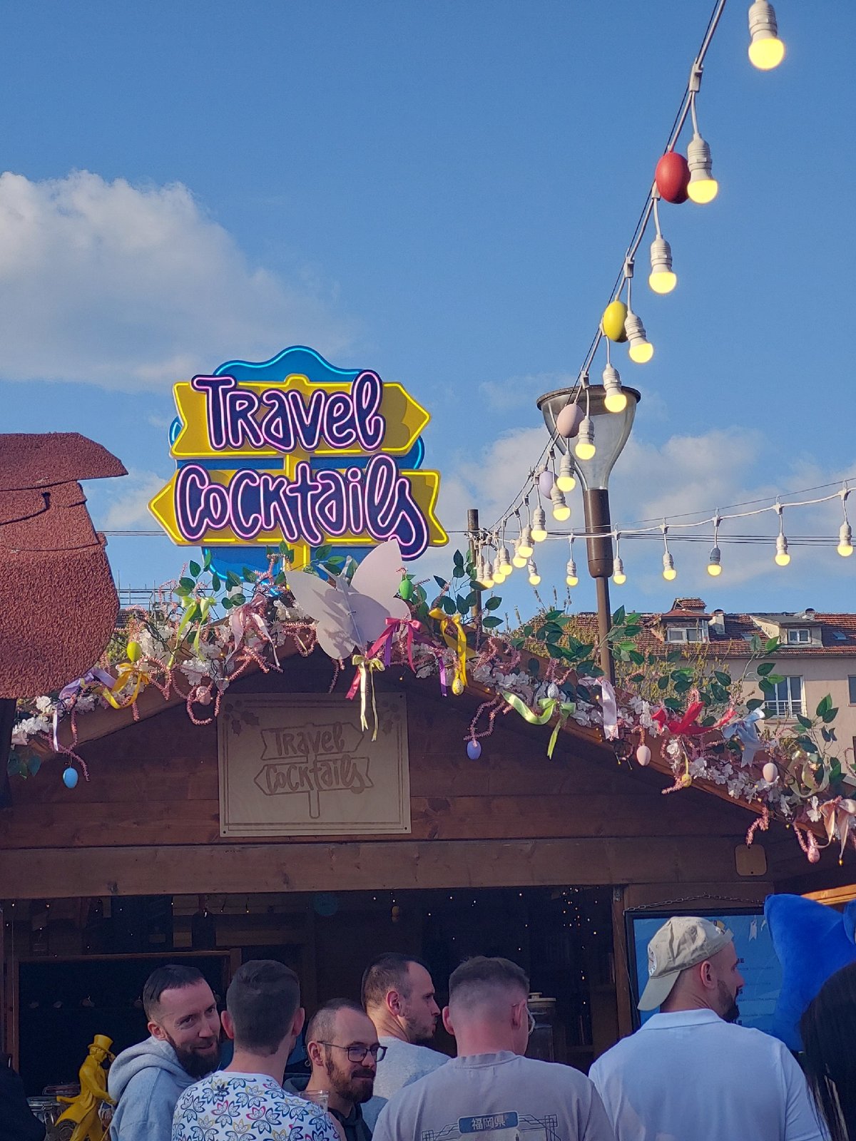 Outdoor market festival documented with Ferris wheel, beverages, murals