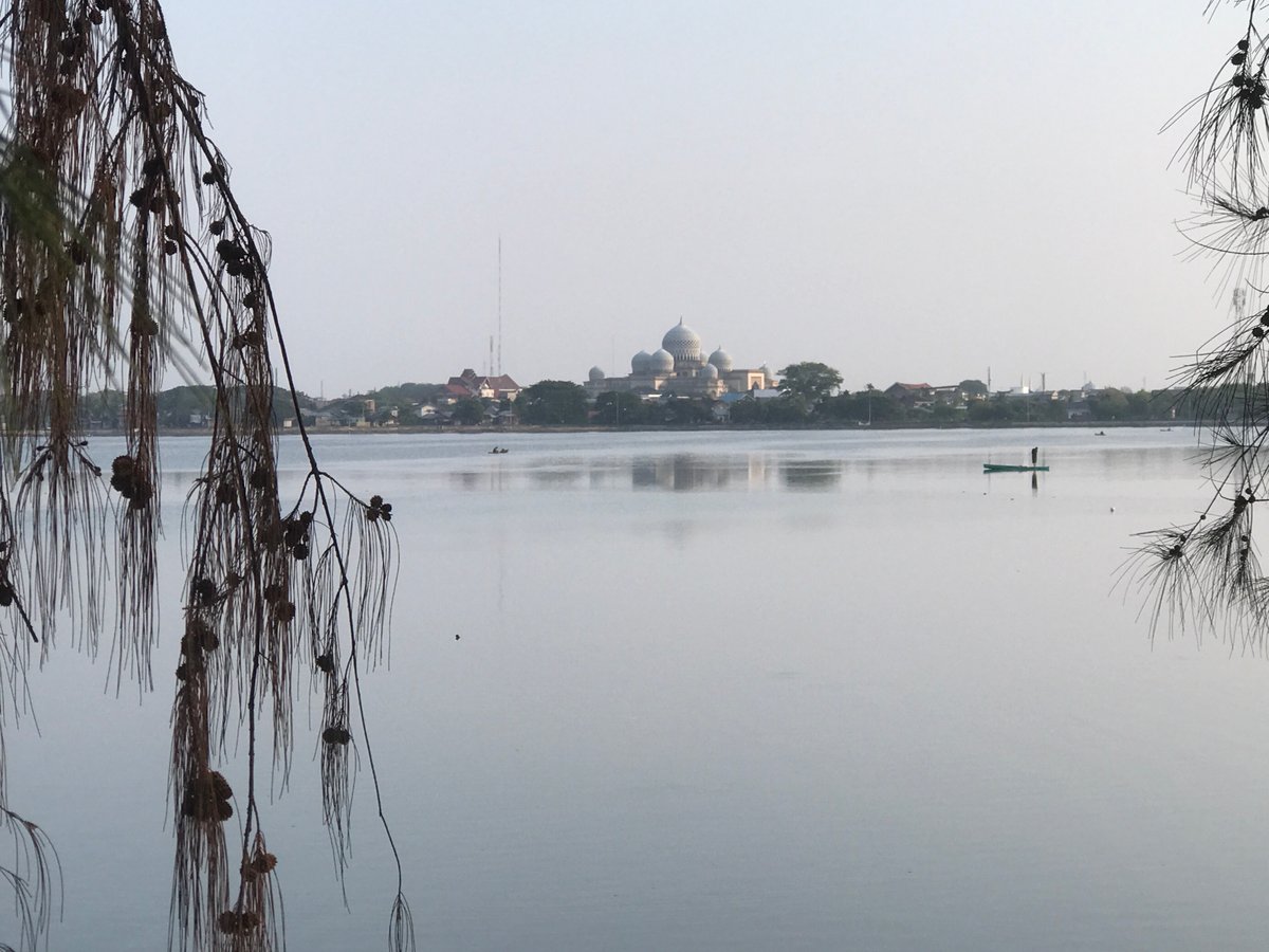 Person on boat photographed near mosque in Lhokseumawe waters