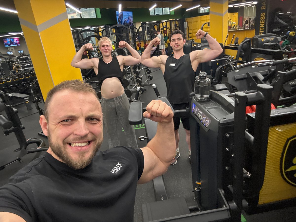 Friends pose for gym selfies during evening workout session