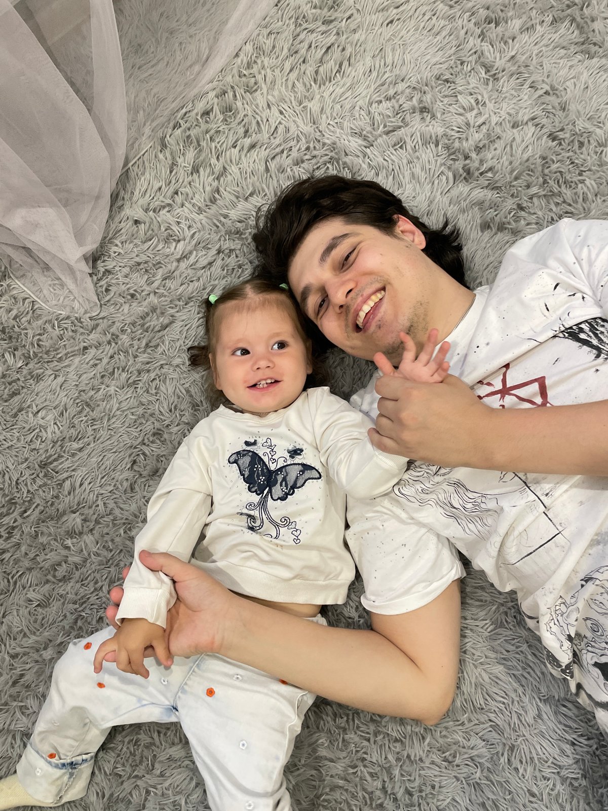 Father and child share quiet moment on rug in Izhevsk