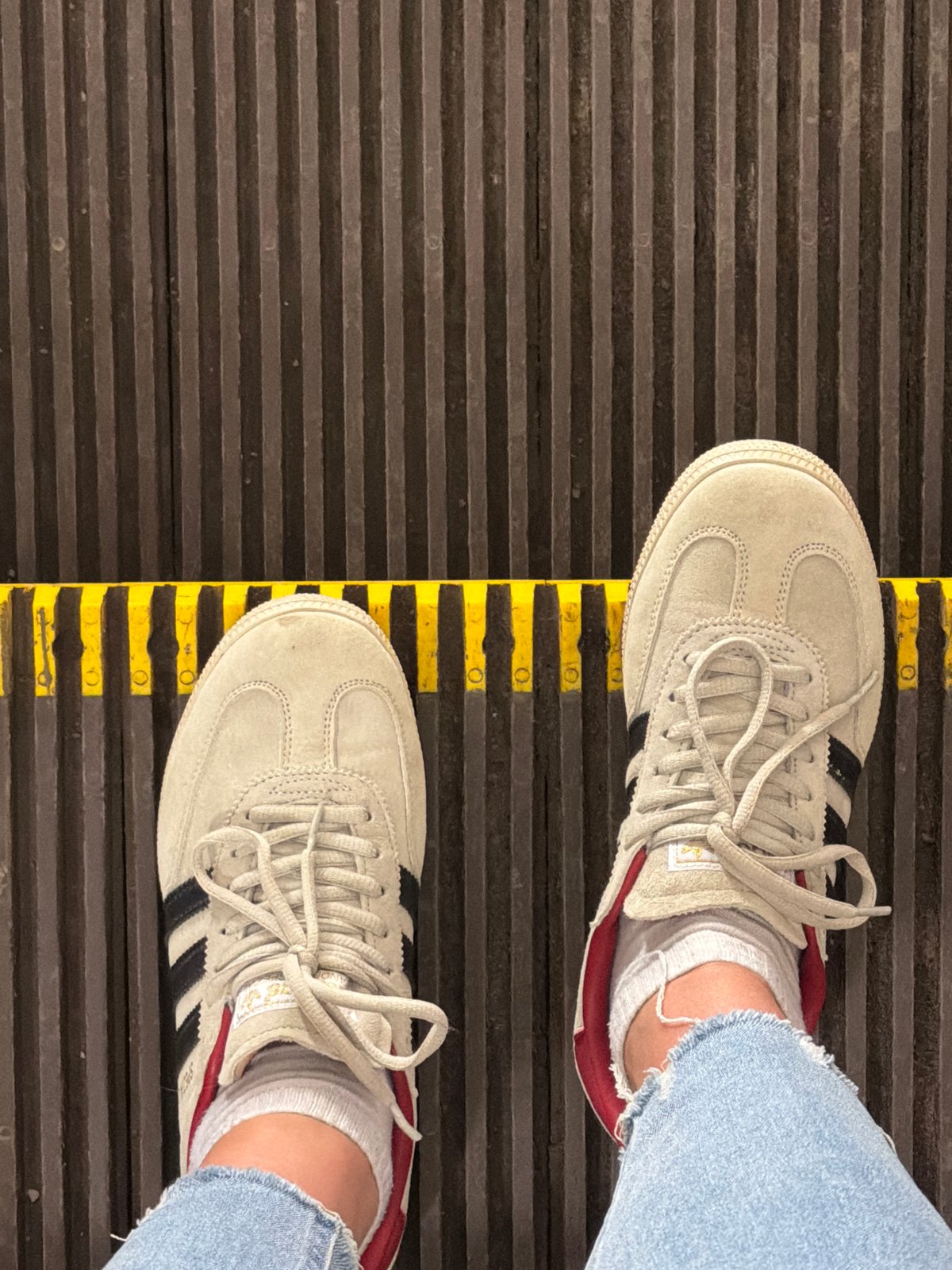 Person in Adidas sneakers rides Moscow escalator early morning