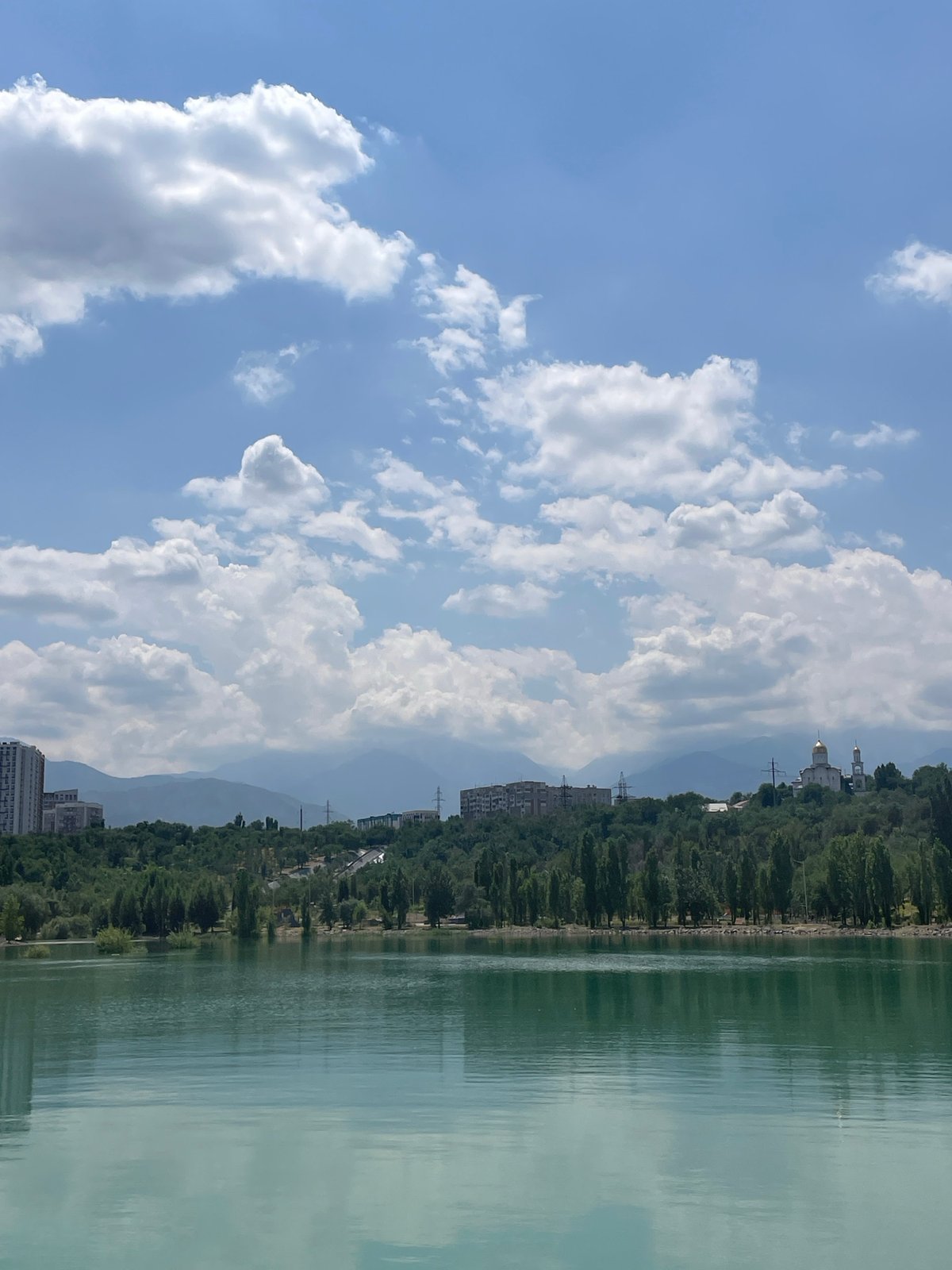 Big Almaty Lake glows turquoise under a clear summer sky