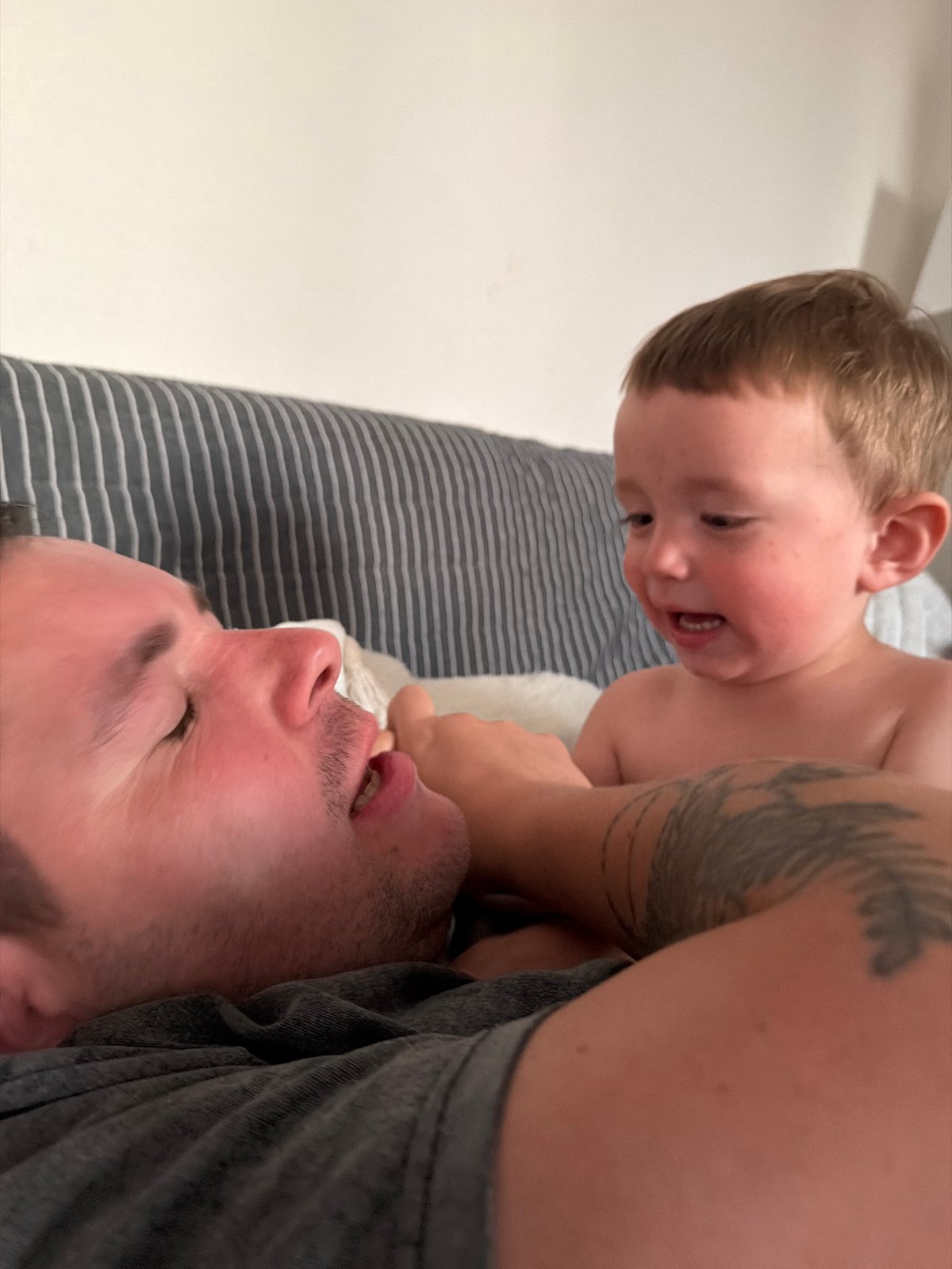 Playful couch moment between adult and child at home