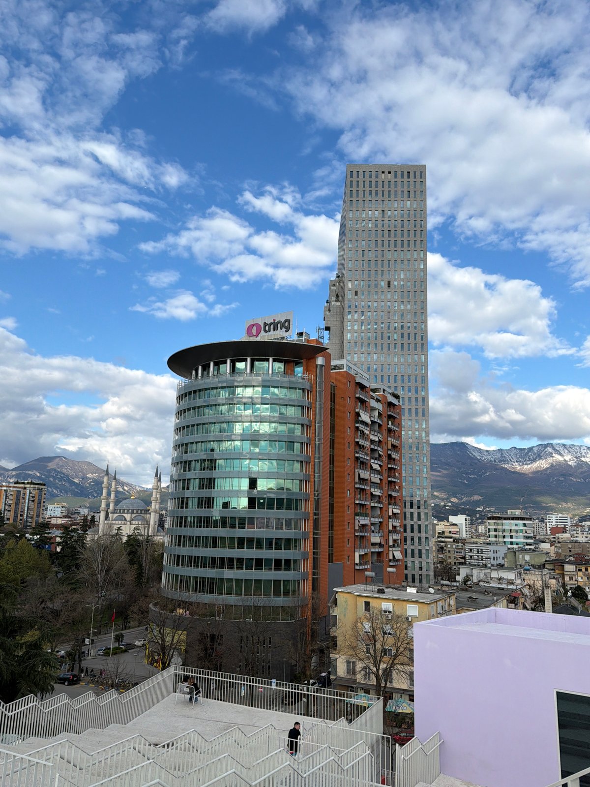 Tourists explore Tirana's rooftops, churches, and art installations
