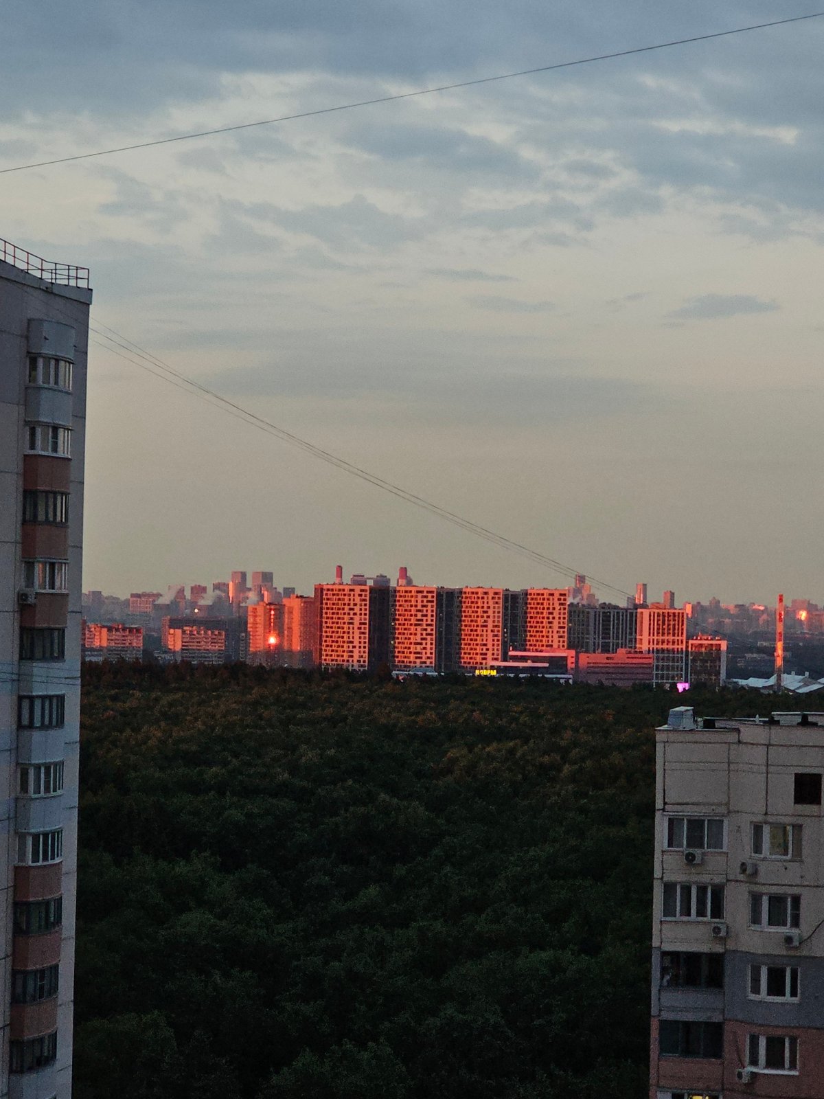 Khimki apartment blocks frame a summer evening sunset