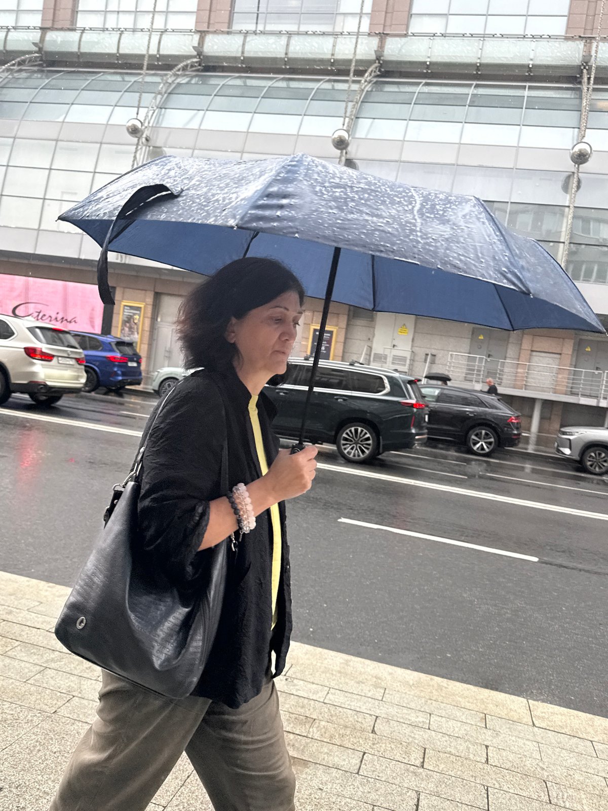 Rainy Moscow street scene with flowers and foot traffic