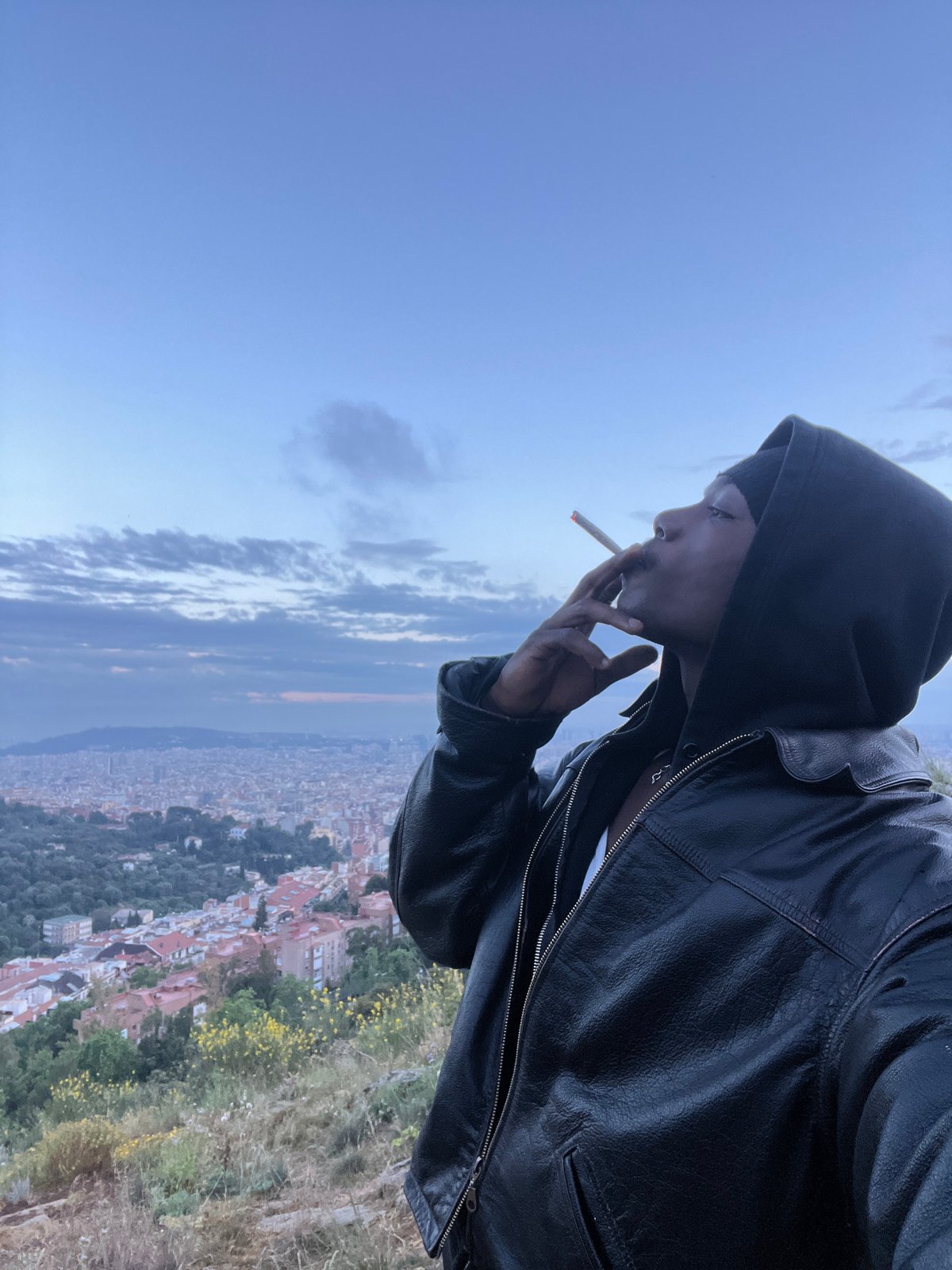 Man smoking on Barcelona hillside overlook captured from multiple angles