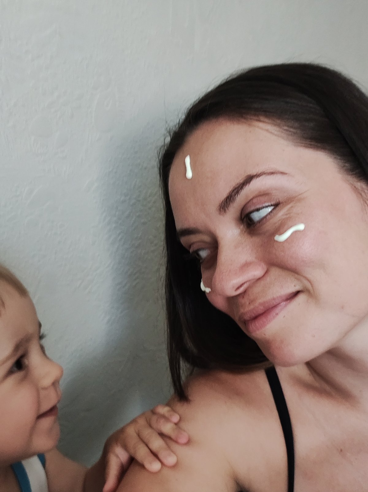 Woman applies face cream during photo session in Chaikovsky