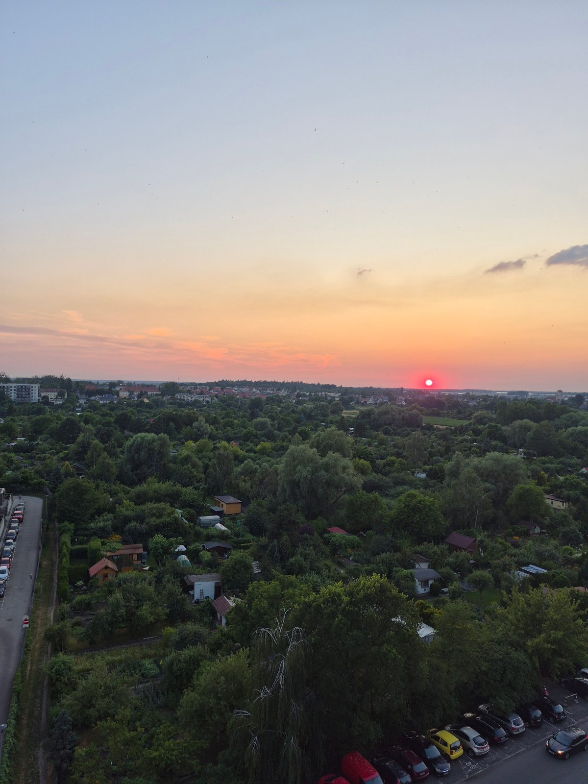 Sunset over a leafy urban-suburban edge from above