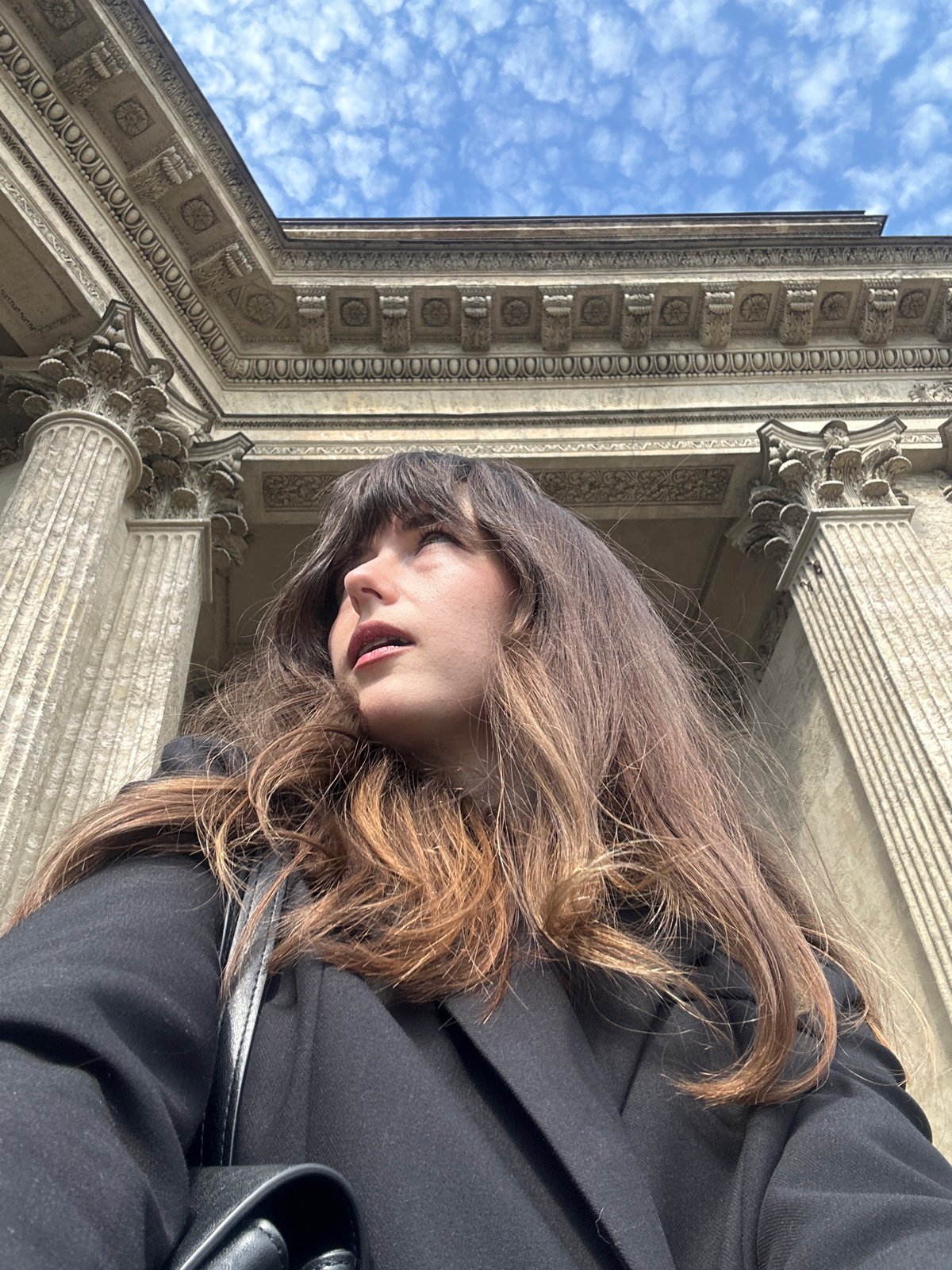 Person photographed near classical building in Saint Petersburg