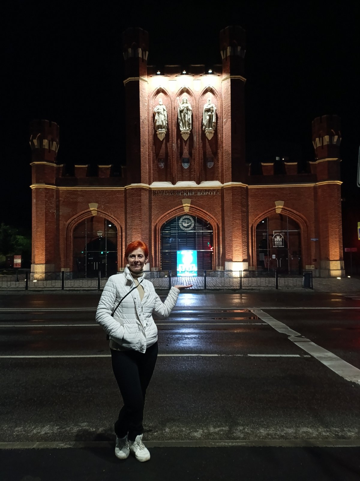 Woman stands on wet crosswalk near Brandenburg Gate, Kaliningrad