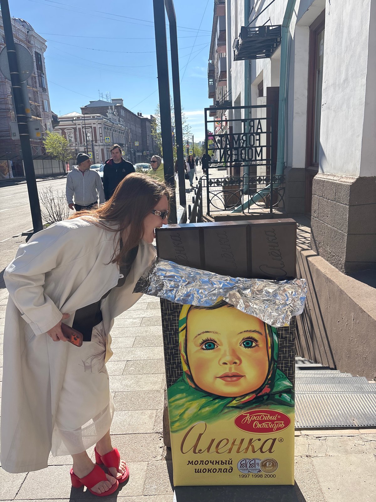 Woman spotted near chocolate ad, food display documented in Krasnoyarsk