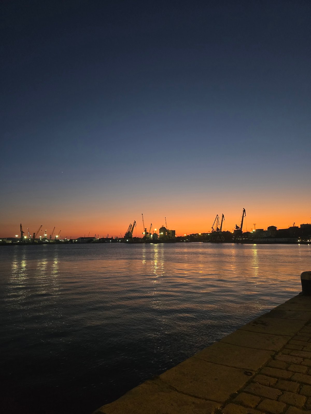 Burgas waterfront at dusk: harbor and cafe under a vivid sunset