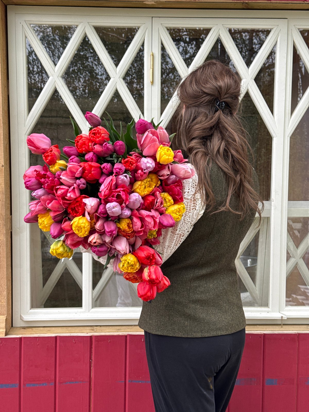 Woman holds colorful tulip bouquet in Sapronovo, Russia