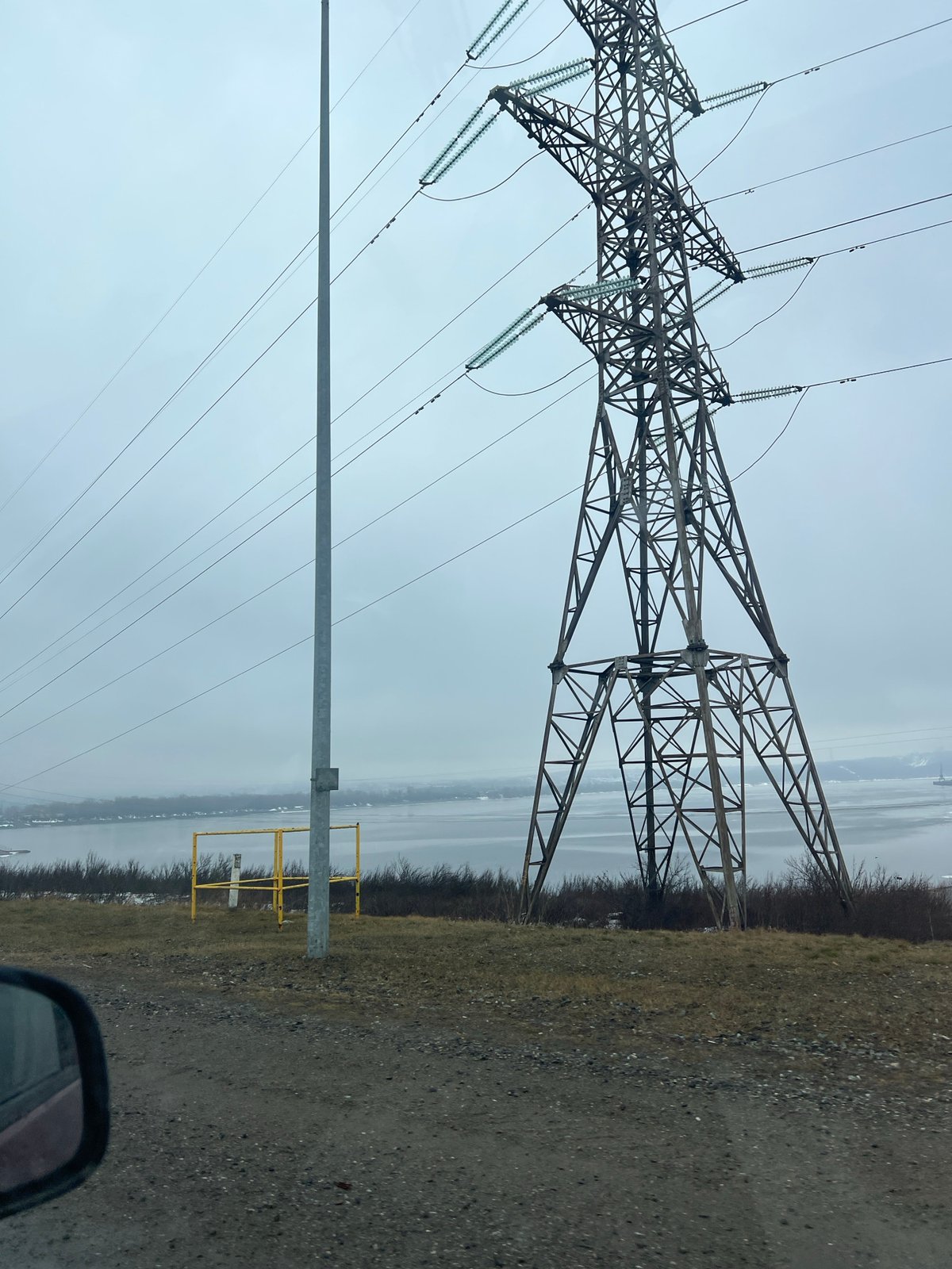 Power transmission tower documented along gravel road in Chaikovsky