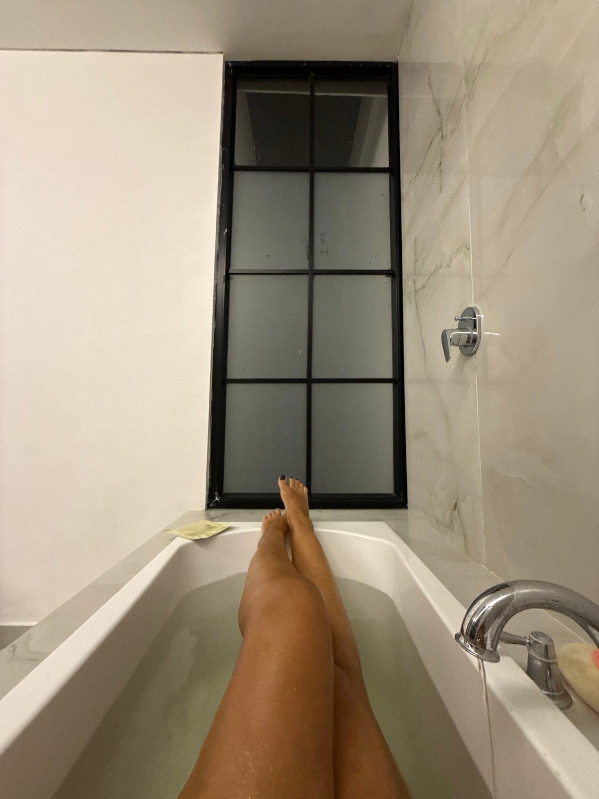 Person bathing in tiled bathroom in North Kuta