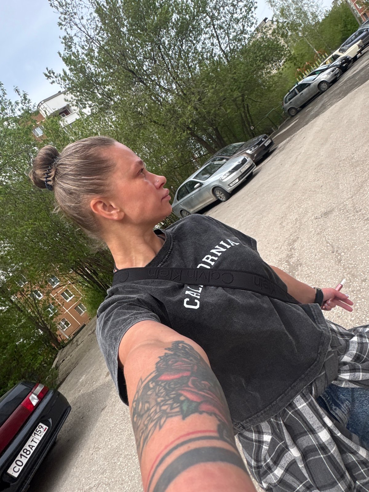Person takes selfie on Perm sidewalk wearing Calvin Klein shirt