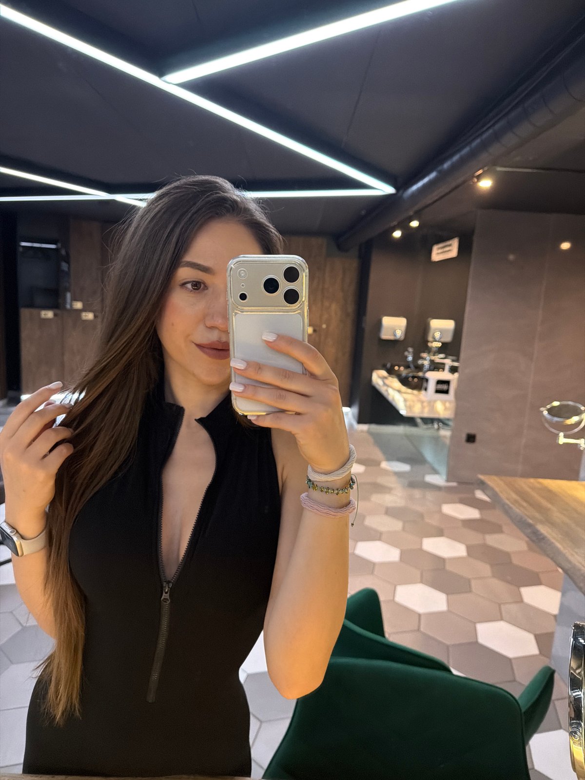 Mirror selfies in a Sofia locker room, black zip-front bodysuit