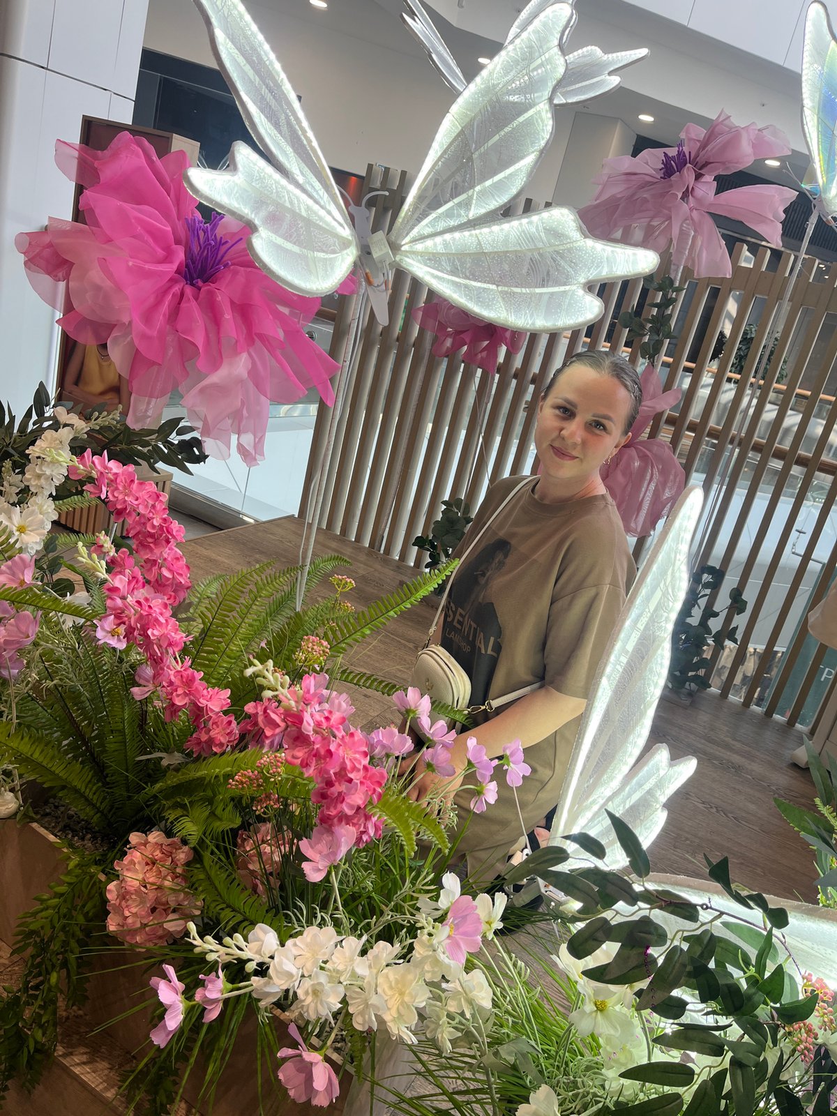 Shopping mall visitors photograph floral displays in Izhevsk